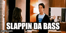 a man is talking to a woman in a living room with the words slappin da bass above him