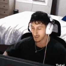 a man wearing headphones is sitting in front of a computer screen
