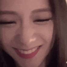 a close up of a woman smiling with her eyes closed .