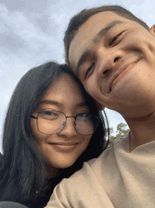 a man and a woman are posing for a picture and the woman has glasses on