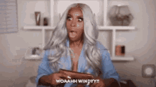 a woman with a surprised look on her face is holding a brush and says woaahh windyy !