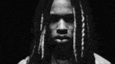 a close up of a man 's face with dreadlocks