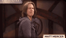 a man is standing in front of a sign that says matt mercer .