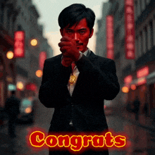 a man in a suit stands in front of a sign that reads congrats