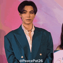 a man in a blue suit is standing in front of a pink and purple background with the hashtag peacepat26