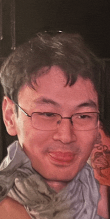a man wearing glasses has a tattoo on his arm that says ' i love you '