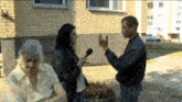 a woman is holding a microphone while talking to an older woman