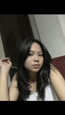 a woman with long black hair is taking a picture of herself