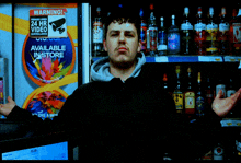 a man stands in front of a sign that says available instore