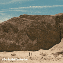 two people standing in front of a large rock formation with #one battle after another written on the bottom