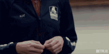 a close up of a person wearing a jacket with kat written on it