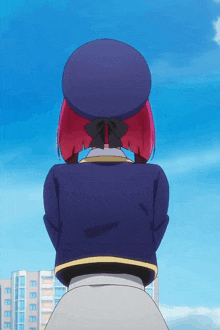 a girl with red hair and a blue hat stands in front of a building