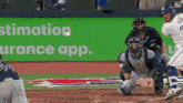 a baseball game is being played in front of a sign that says ' estimation insurance app '