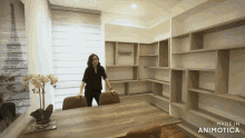 a woman is standing in a room with shelves and a sign that says made in animotica