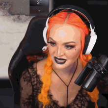 a woman with orange hair is sitting in front of a microphone with the number 2f visible in the background