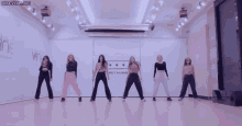 a group of girls are dancing in a room with a sign that says net number