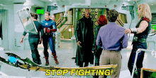 a group of people are standing around a table with the words stop fighting on it