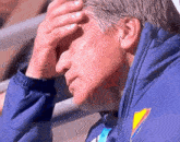 a man wearing a blue jacket with a yellow and blue emblem on the sleeve