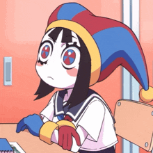 a cartoon girl wearing a jester hat sits at a desk