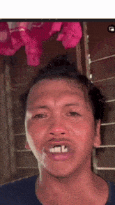 a close up of a man making a funny face with a pink background