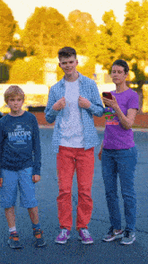 a boy wearing a hansen 's shirt stands next to a woman