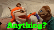 a couple of puppets sitting on a bed with the word anything in green