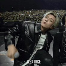 a man in a black leather jacket has alex dice written on the bottom of his jacket