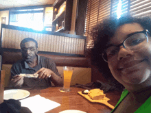 a man and a woman are sitting at a restaurant table