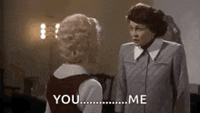 two women are standing next to each other and talking .