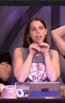 a woman sitting at a table with her hands on her face