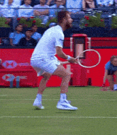 a man holding a tennis racquet on a court