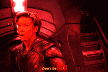 a man in a dark room with the words " do n't be red " on the bottom right