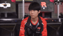 a man wearing a red and black jacket with the word nongs on the front