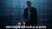 a man in a suit and tie is standing in a dark room with the words didn 't imagine that would go so quickly