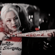 a woman in a daddy 's monster costume is holding a bat .