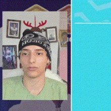 a man wearing a hat that says ' xmas ' on it is standing in front of a wall with pictures on it