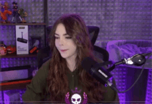 a woman is sitting in front of a shure microphone in a room .