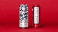two budweiser cans are sitting next to each other on a red background .
