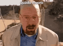a man with glasses and a beard is making a funny face with the words quado muoro written above him .