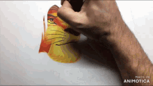 a person is drawing a lion on a piece of paper with the words made in animatica on the bottom