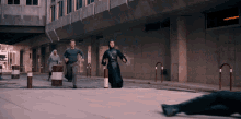 a group of people are running down a street and one of them is wearing a hoodie that says ' a ' on it