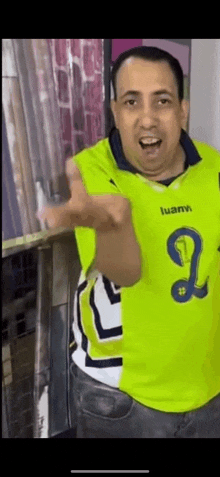 a man wearing a yellow and white jersey is giving a thumbs up .