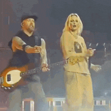 a man is playing a guitar next to a woman who is singing