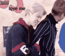 a couple of men standing next to each other with the words `` love me '' written on the bottom .