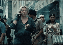 a woman is talking on a cell phone in a crowded street