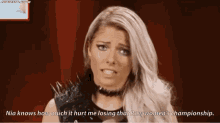 a woman with a choker and spikes on her shoulder is talking about bullies .