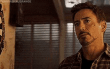 a man with a beard is wearing a plaid shirt .