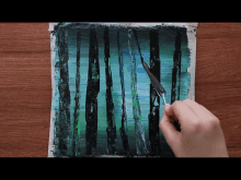 a person is painting a picture of a forest with a brush