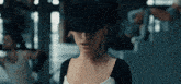 a woman wearing a black hat is standing in a gym