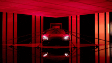 a car is chained to a wall in a room with red lights